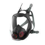 A full face respirator with a clear panoramic visor, black in color, equipped with a red exhalation valve and adjustable head harness.