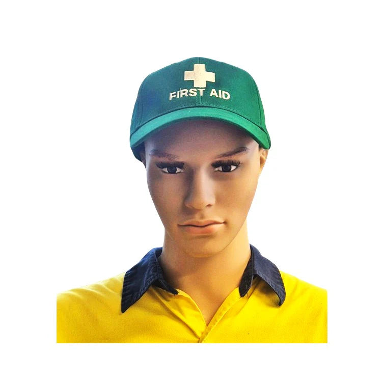 Person wearing a green 'First Aid' cap on a white background